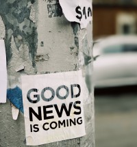 sign on light pole indicating good news is coming