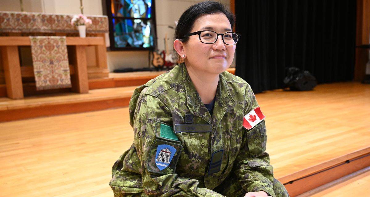 Capt. Joanne Yuasa sits in a serene chapel, flashing a warm smile at the camera. She is dressed in her green Canadian Forces army fatigues.