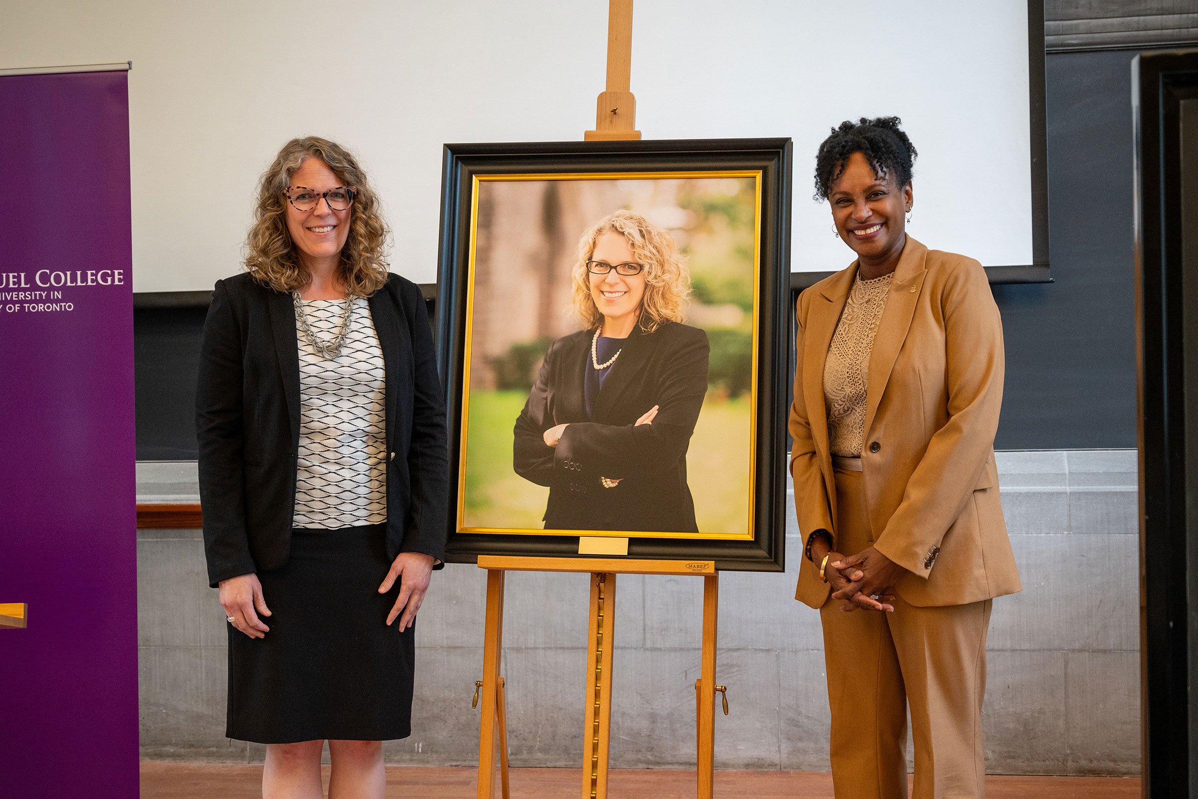 Michelle Voss and Victoria University President Rhonda N. McEwen stand on either side of a portrait of Michelle Voss.