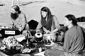 Three musicians playing traditional Indian instruments. 